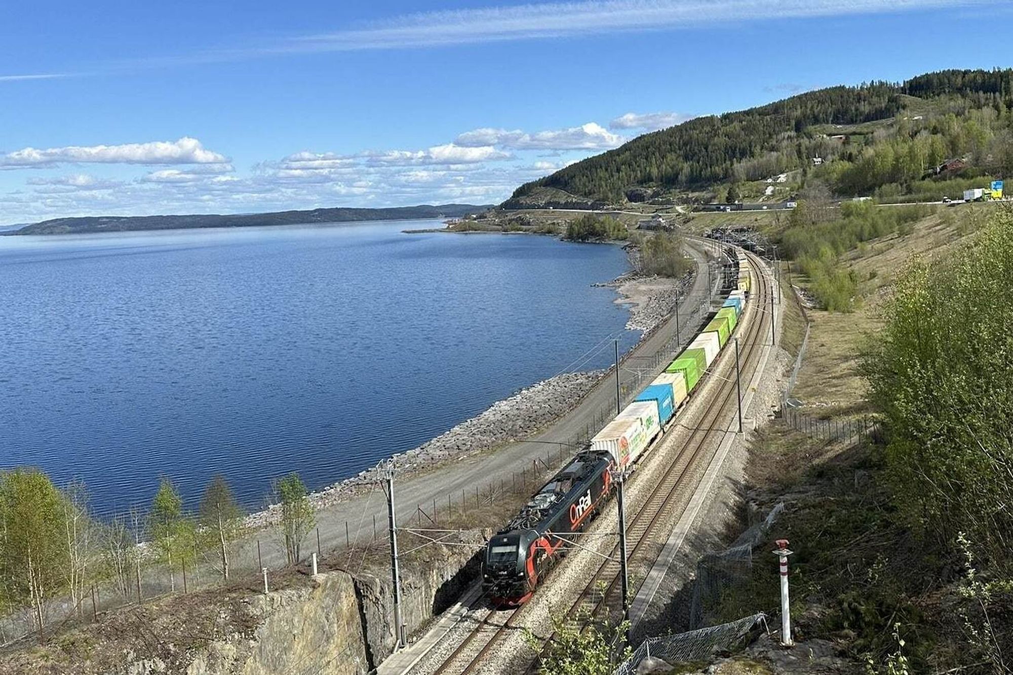 Et godstog fra Onrail kjører fra Åndalsnes på dobbeltsporet langs Mjøsa.