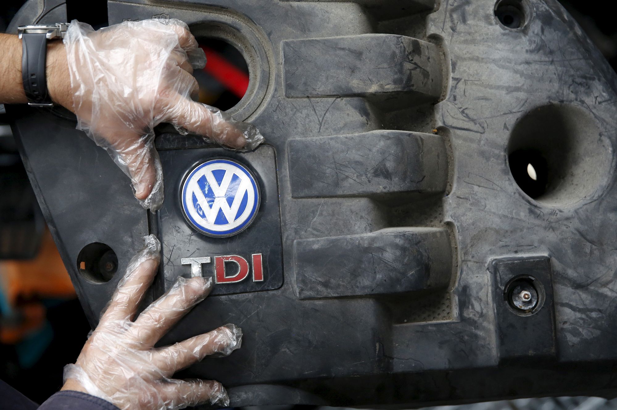 En arbeider viser frem dekselet til en TDI-dieselmotor fra Volkswagen. Bildet er fra 2015, etter at dieselskandalen sprakk.