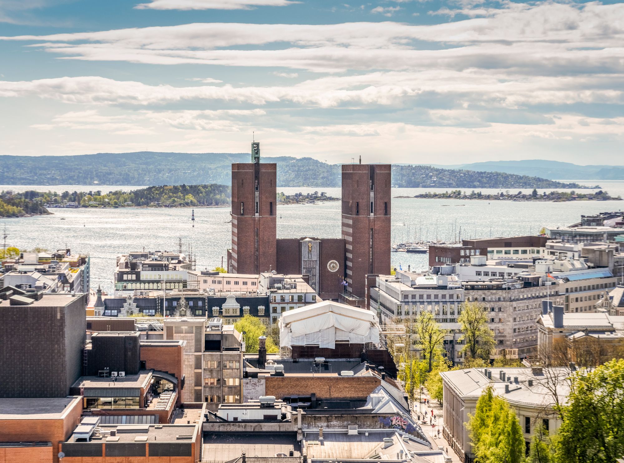 Oslo rådhus og Oslo sentrum en lys vårdag i mai. Byrådet har vedtatt å legge ned Oslo Origo, som er kommunes felles satsing på digital transformasjon. De vil samtidig opprette en ny digitaliseringsetat.