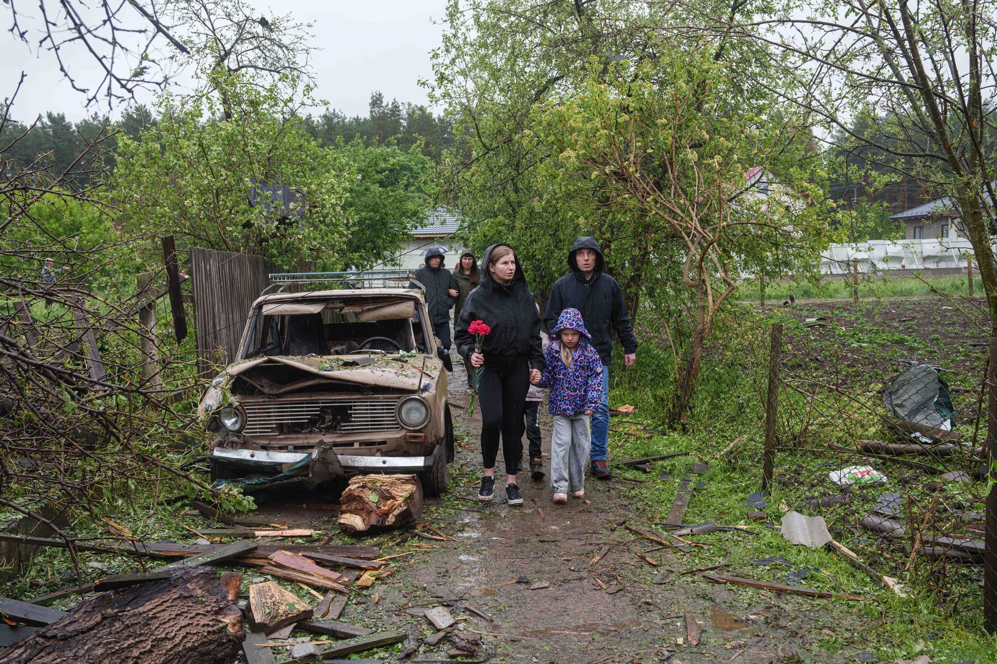 Innbyggere kommer med blomster til ruinene av et hus der tre barn ble drept i i et russisk angrep i Zhytomyr-regionen i Ukraina forrige uke.