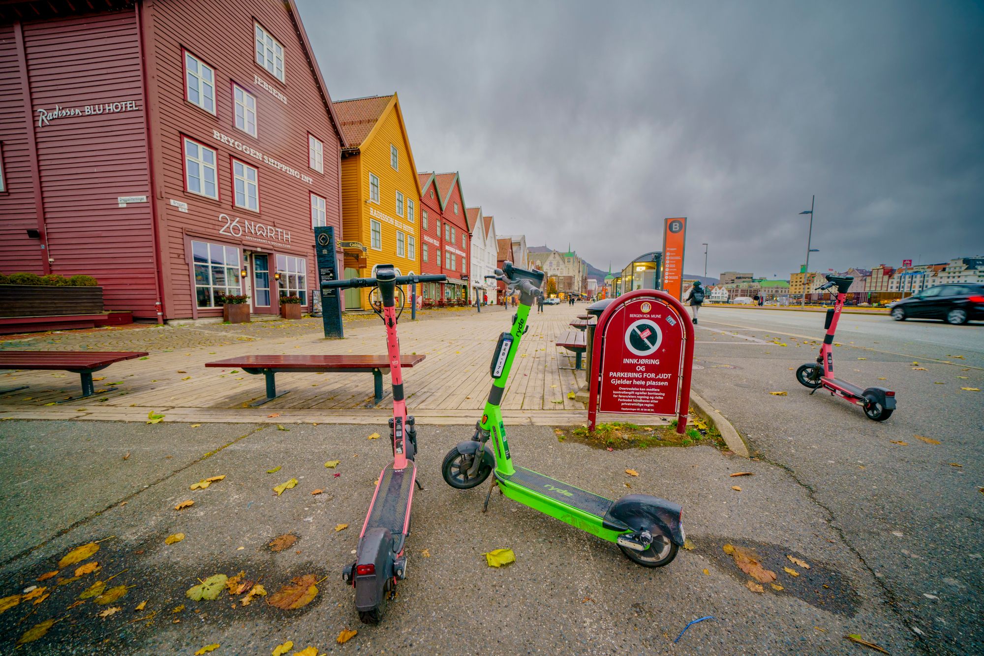 To elsparkesykler står parkert utenfor Bryggen i Bergen. Feilparkerte elsparkesykler har gitt millioninntekter til kommunen de siste årene.