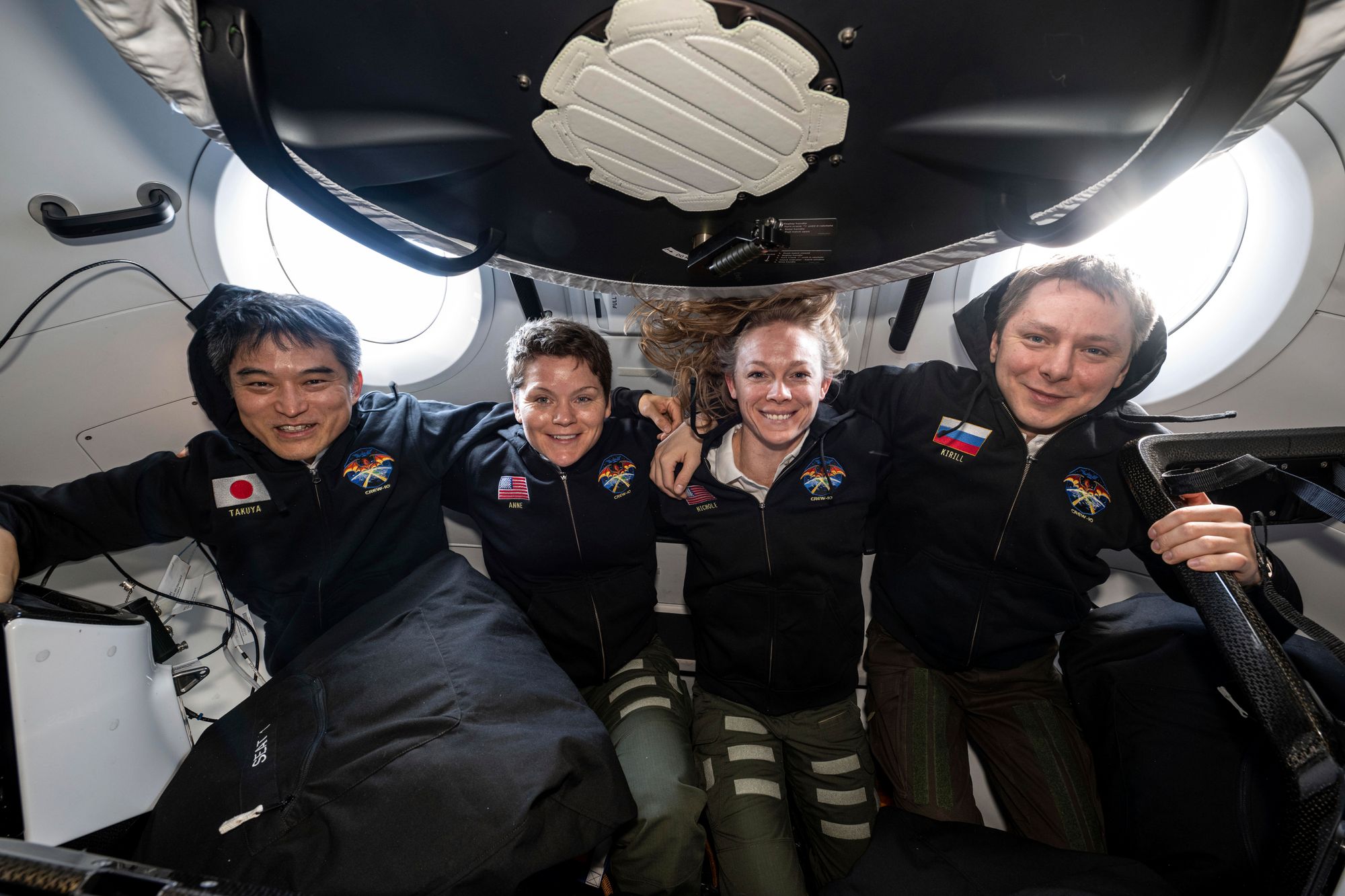 Takuya Onishi fra Japan (t.v.), Anne McClain og Nichole Ayers fra USA og russiske Kirill Peskov på plass i romkapselen som skal føre dem tilbake til jorden etter endt oppdrag på Den internasjonale romstasjonen.