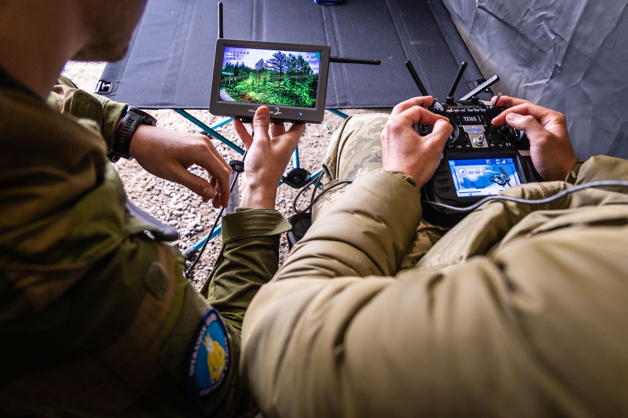 En norsk instruktør følger med på skjermen om hvor og hvordan en ukrainer flyr med drone under et droneoperatørkurs i operasjon Gungne tidligere i år.