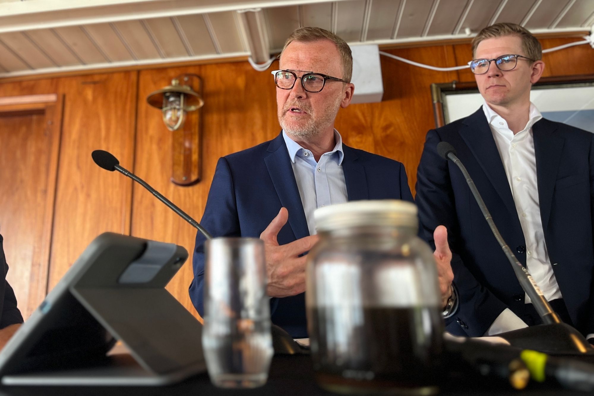 Bak en halvfull/halvtom krukke med råolje argumenterer raffinerisjef Bernt Tysseland for at staten må bidra til at Equinors raffineri på Mongstad kan moderniseres. Til høyre Sverre Lindseth, partner i BCG. 