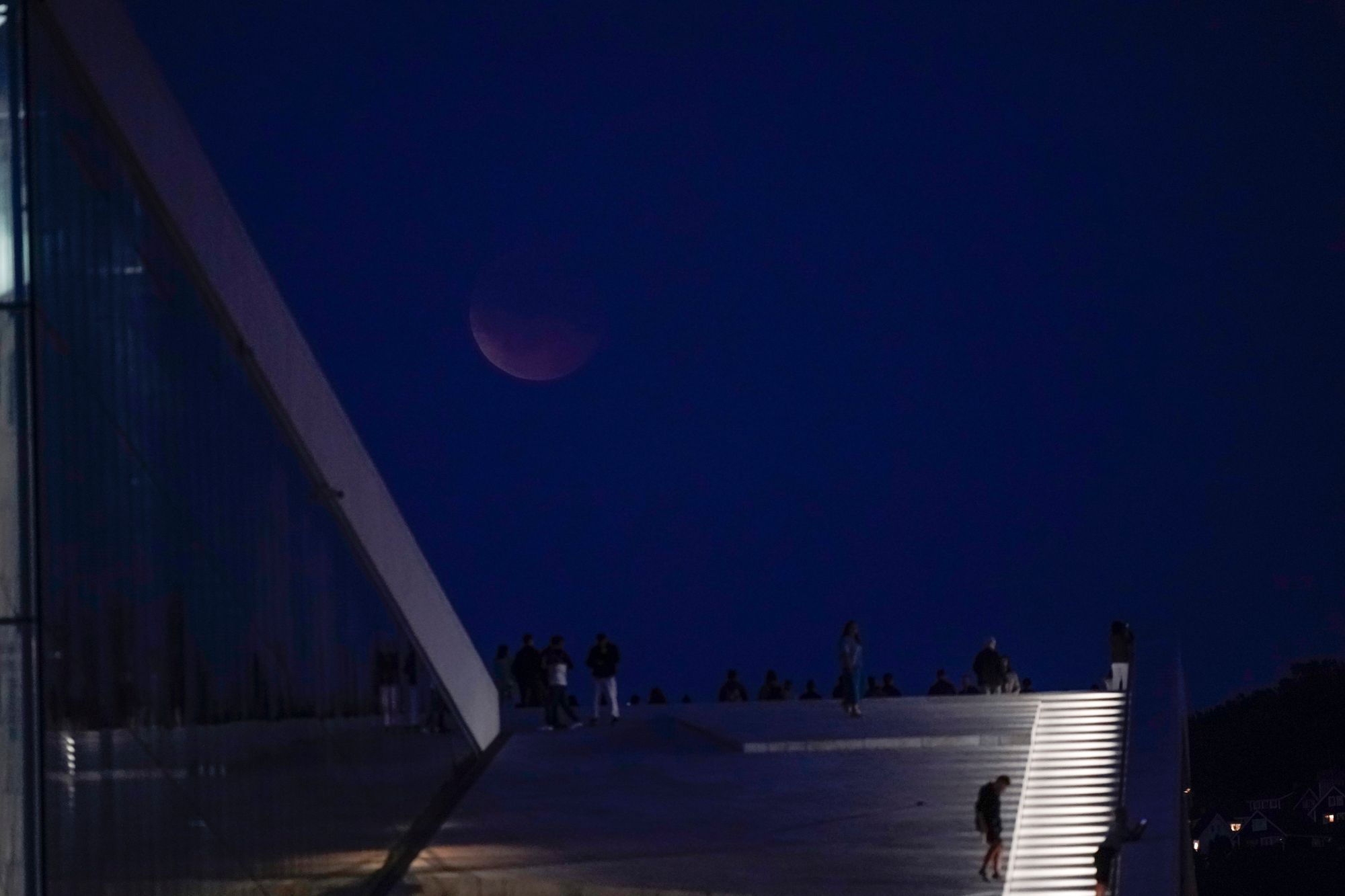 Blodmåne over Operaen i Oslo der flere hadde samlet seg på taket for å se måneformørkelsen. 
