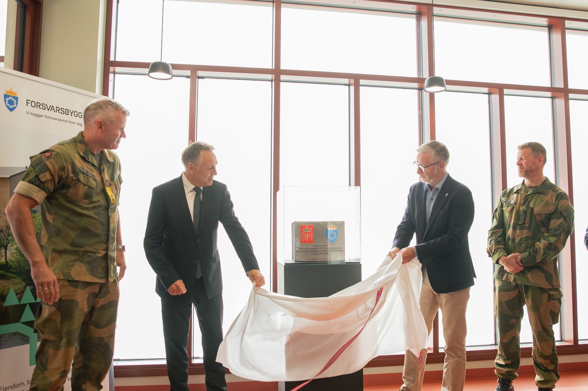 Her avdekker forsvarsminister Tore O. Sandvik og tidligere forsvarsbygg-sjef Thorbjørn Thoresen grunnsteinen til ny garnison i Porsanger i 2025.