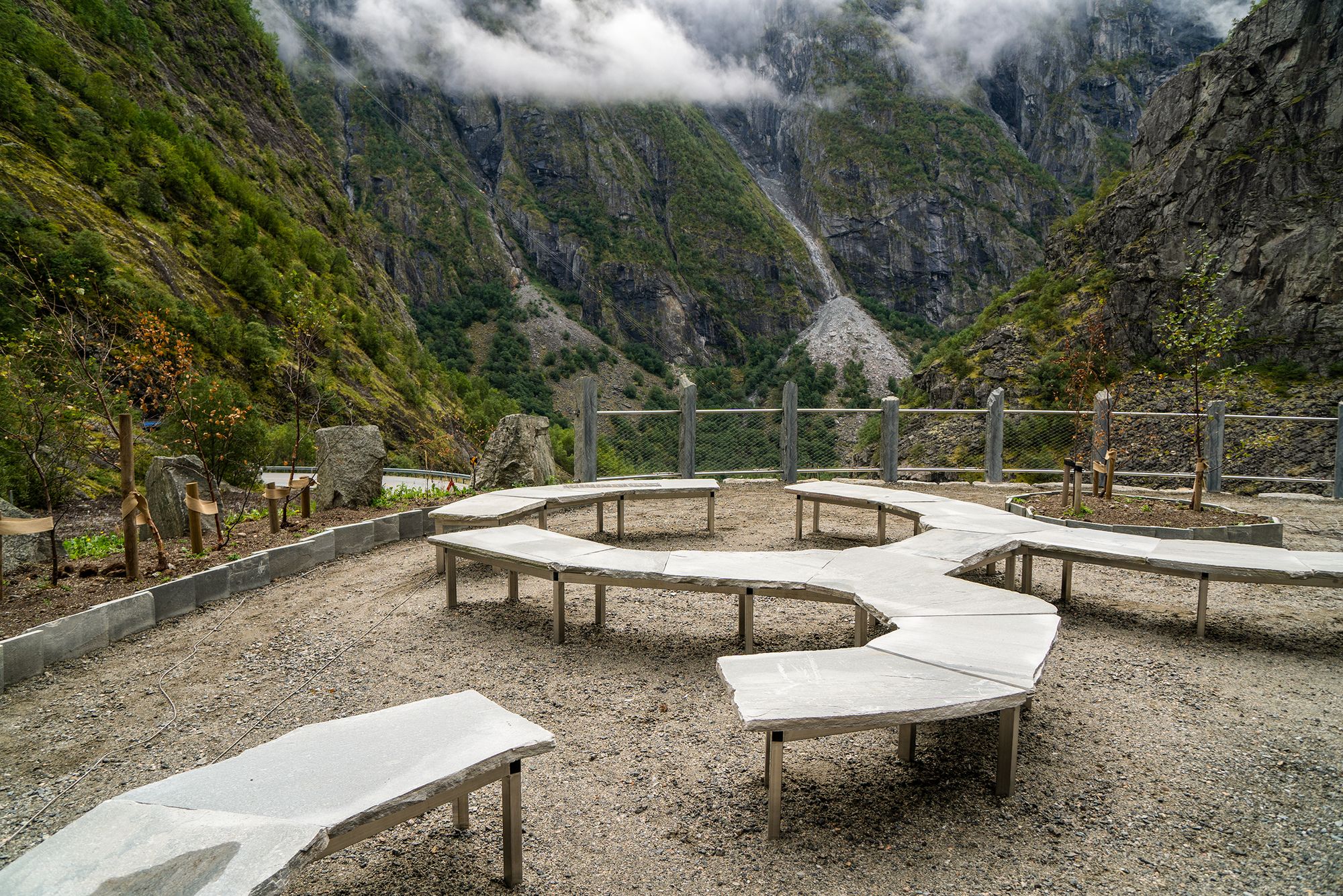 Rasteplassen har en rund form med buktende benker. Måbø bru rasteplass, riksvei 7.