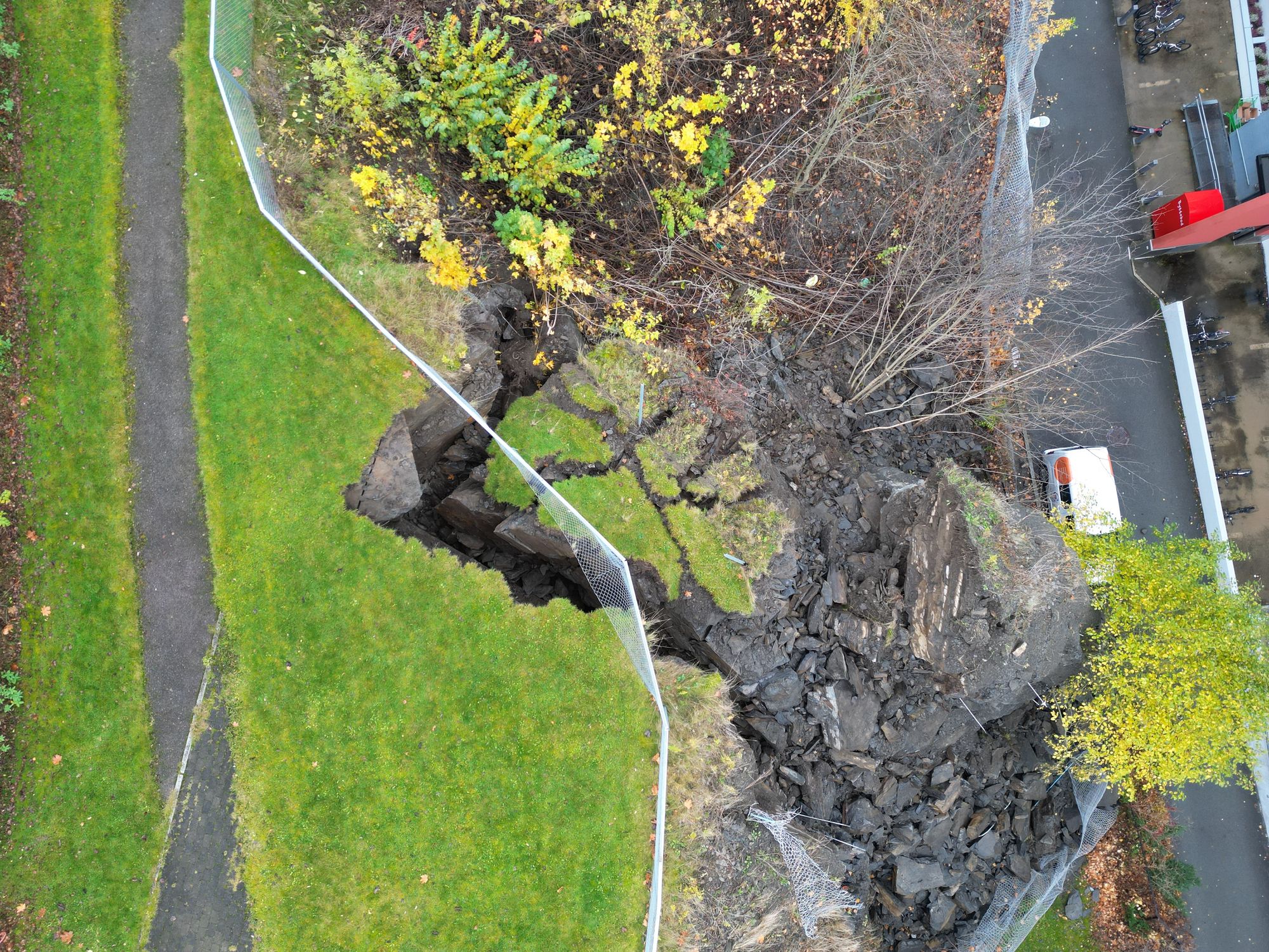 Rester av sikringsnettet som ble revet ned av skredet som gikk søndag er synlig på bildet. Studenthuset til venstre og boligsameiet Sukkertoppen til høyre i bildet.
