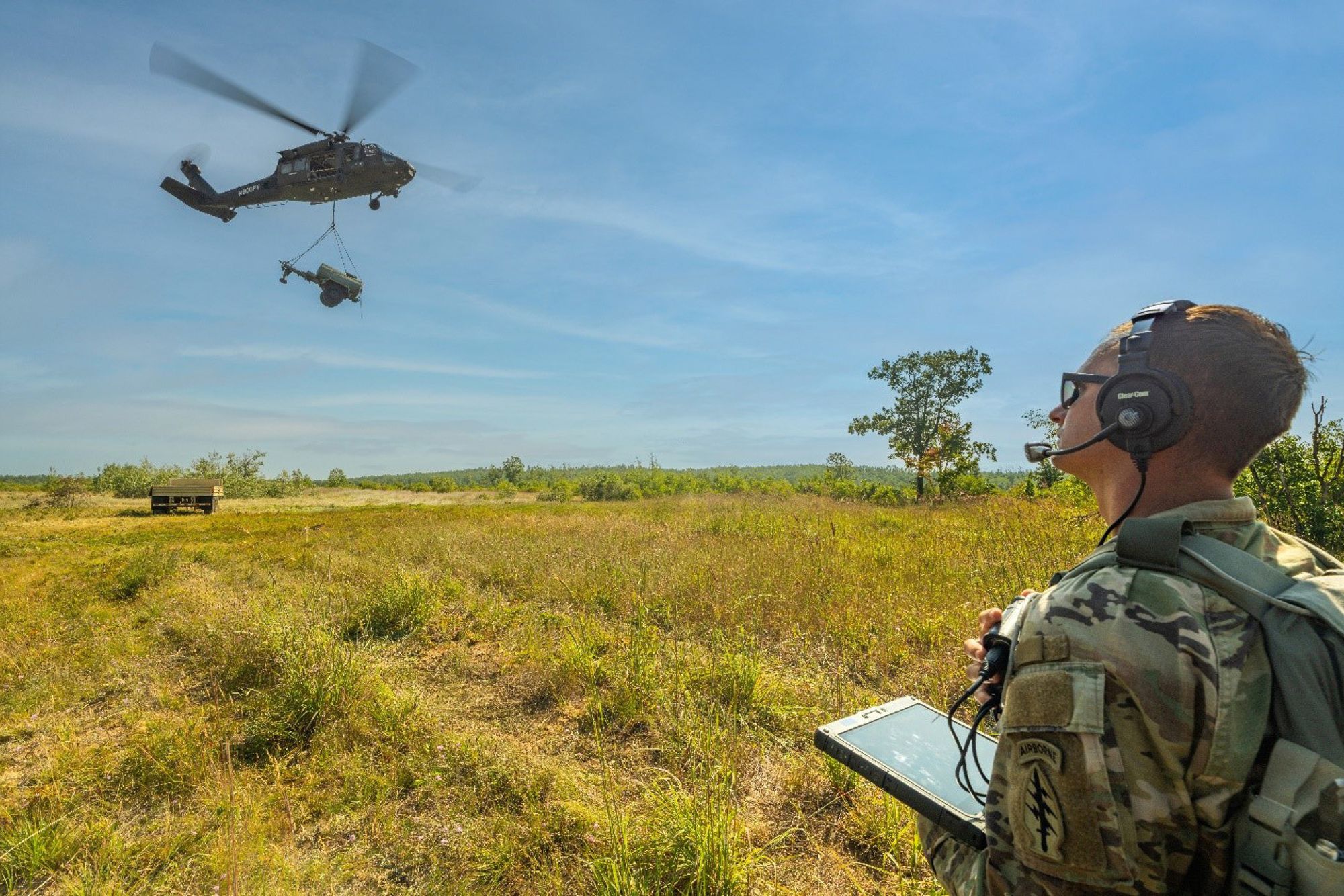 En amerikansk soldat bruker et nettbrett til å kommandere et autonomt Black Hawk-helikopter til å frakte en vanntank på 1,3 tonn under øvelsen Northern Strike i Michigan, USA i august 2025.