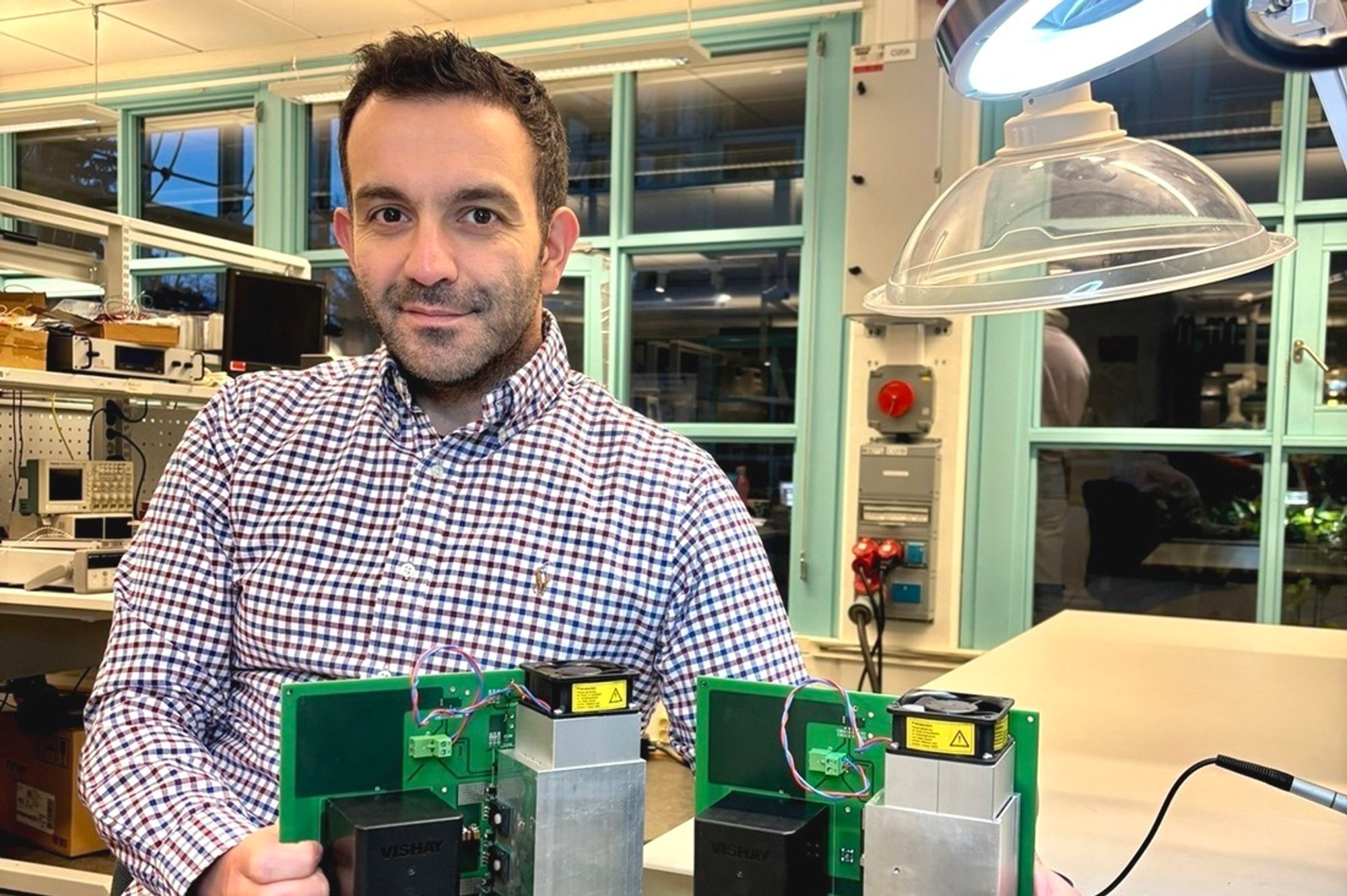 Professor Dimosthenis Peftitsis i laboratoriet med noen prototyper på den nye elektronikken.