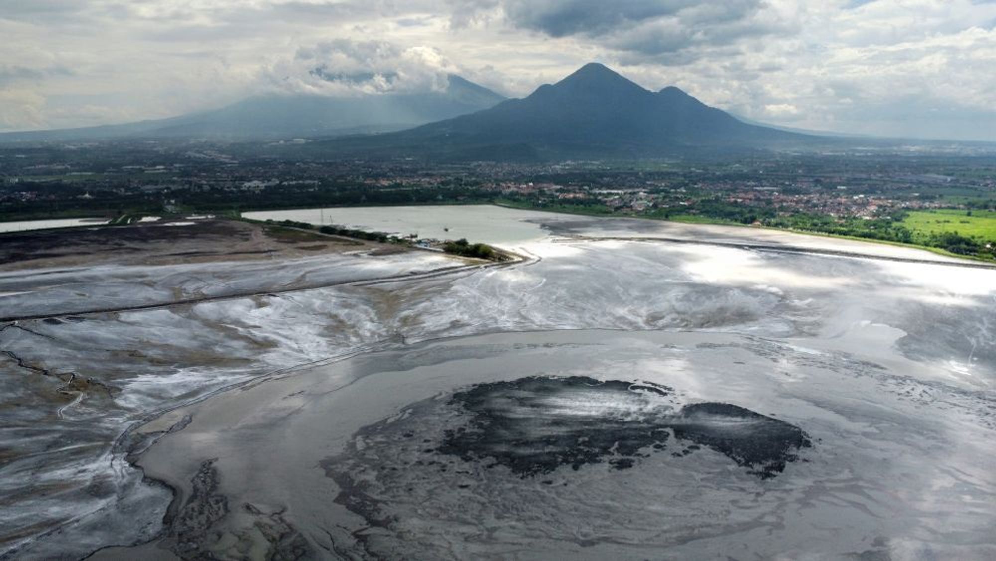 Dronebilete frå Lusi-utbrotet; i bakgrunnen det nærliggande Arjuno–Welirang-vulkankomplekset.