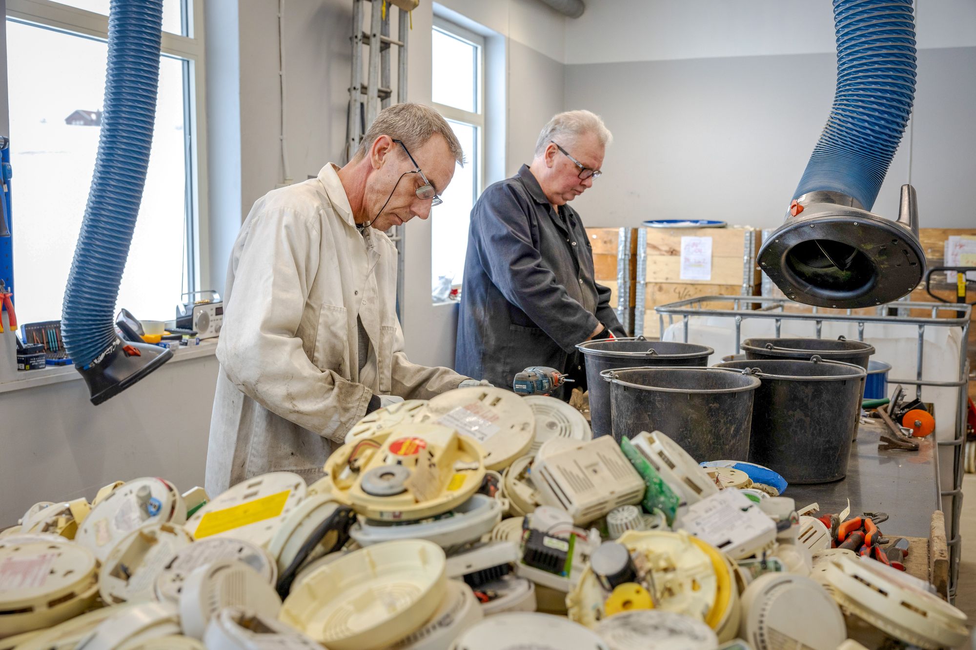 Demontering av røykvarslere må gjøres manuelt av ansatte ved IFE før den radioaktive kilden kan skilles ut og lagres i beholdere. Her jobber teknikerne Petter Holmen(t.v.) og Vegard Kvebæk. 