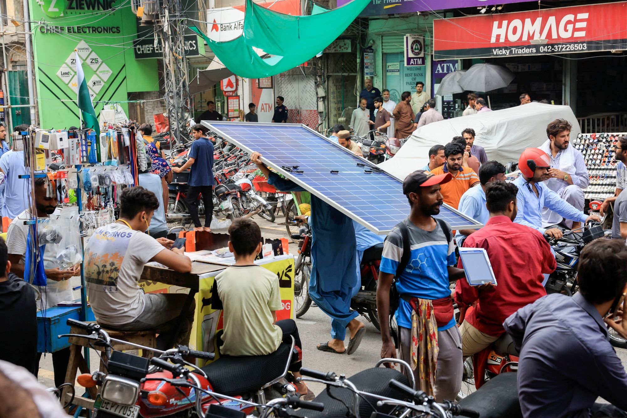 En person bærer et solcellepanel gjennom et elektronikkmarked i Lahore i Pakistan. Den raske utrullingen av solceller på bygninger gjør at landet kan spare store summer på import av olje og gass i 2026.