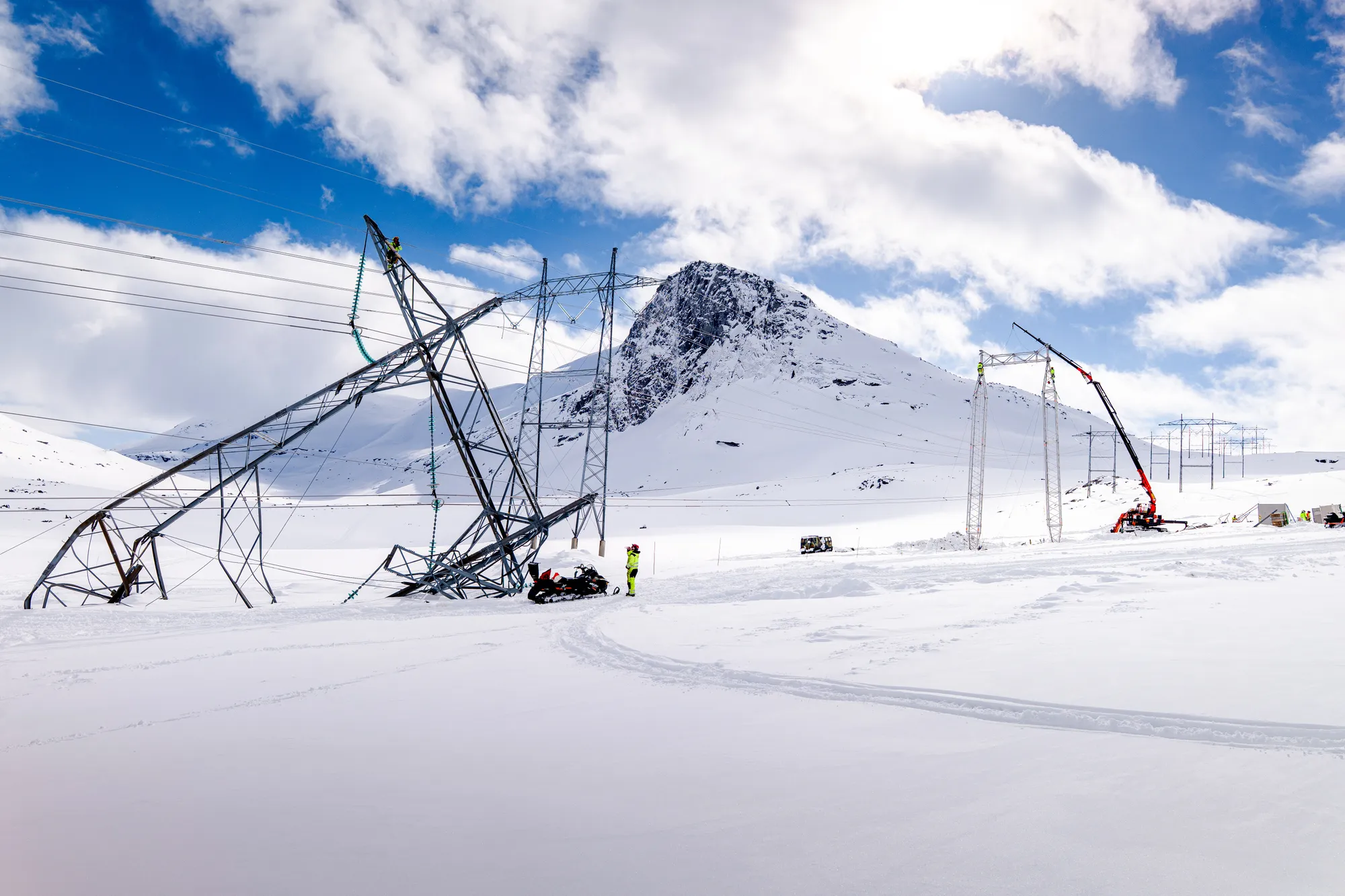 I fjor vinter ble høyspentmaster i Narvik-området tatt av snøskred. Bildet viser havarert mast og oppbygging av midlertidige beredskapsmaster i bakgrunnen. 