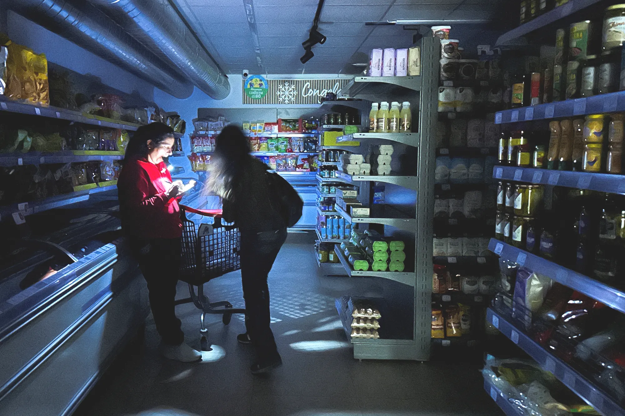 En butikkansatt i Barcelona måtte frem med lommelykten for å hjelpe en kunde under strømbruddet i Spania i fjor.