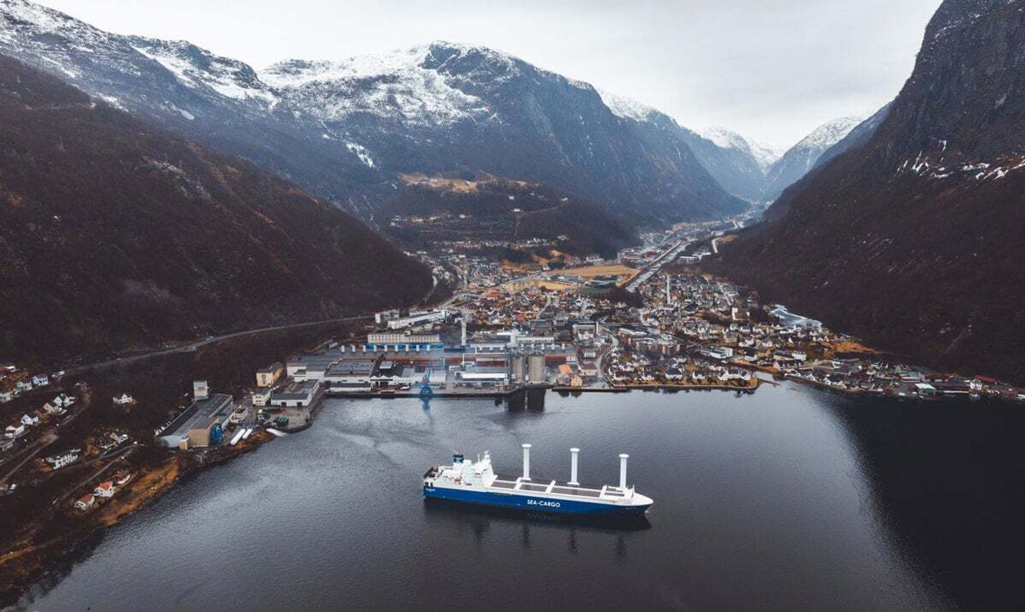 Trans Sol har rotorseil, solceller, batterilagring, optimaliserte propeller og landstrøm. Her på vei ut fra Hydros aluminiumverk i Høyanger med valseblokk til det europeiske markedet. 