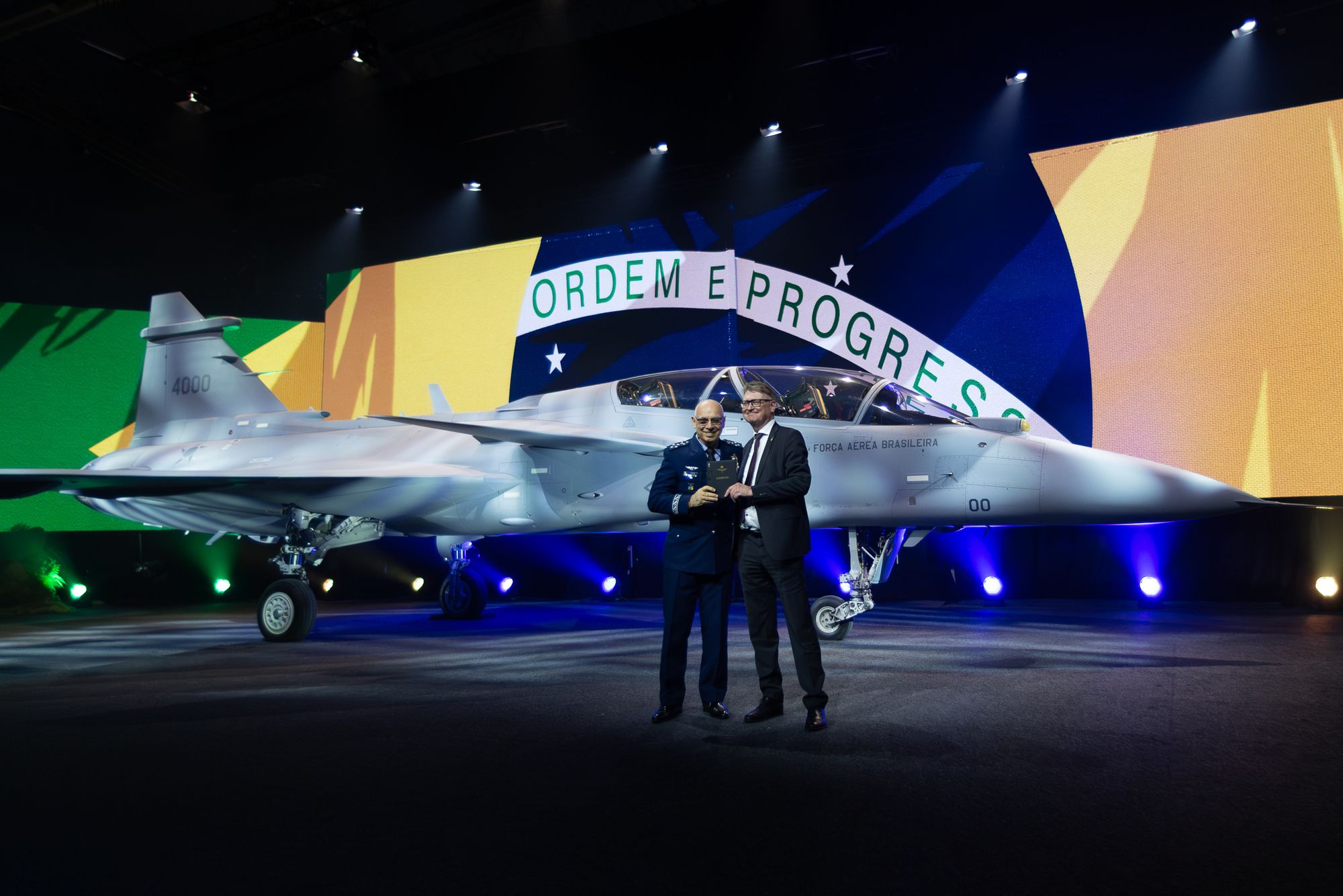 General Marcelo Kanitz Damasceno, sjef for det brasilianske luftforsvaret, og Lars Tossman, sjef for Saabs aeronics-forretningsområde, foran det første Gripen F-flyet som denne uken ble avduket i Linköping. Flyet skal senere leveres til Brasil. Foto fra 2026.