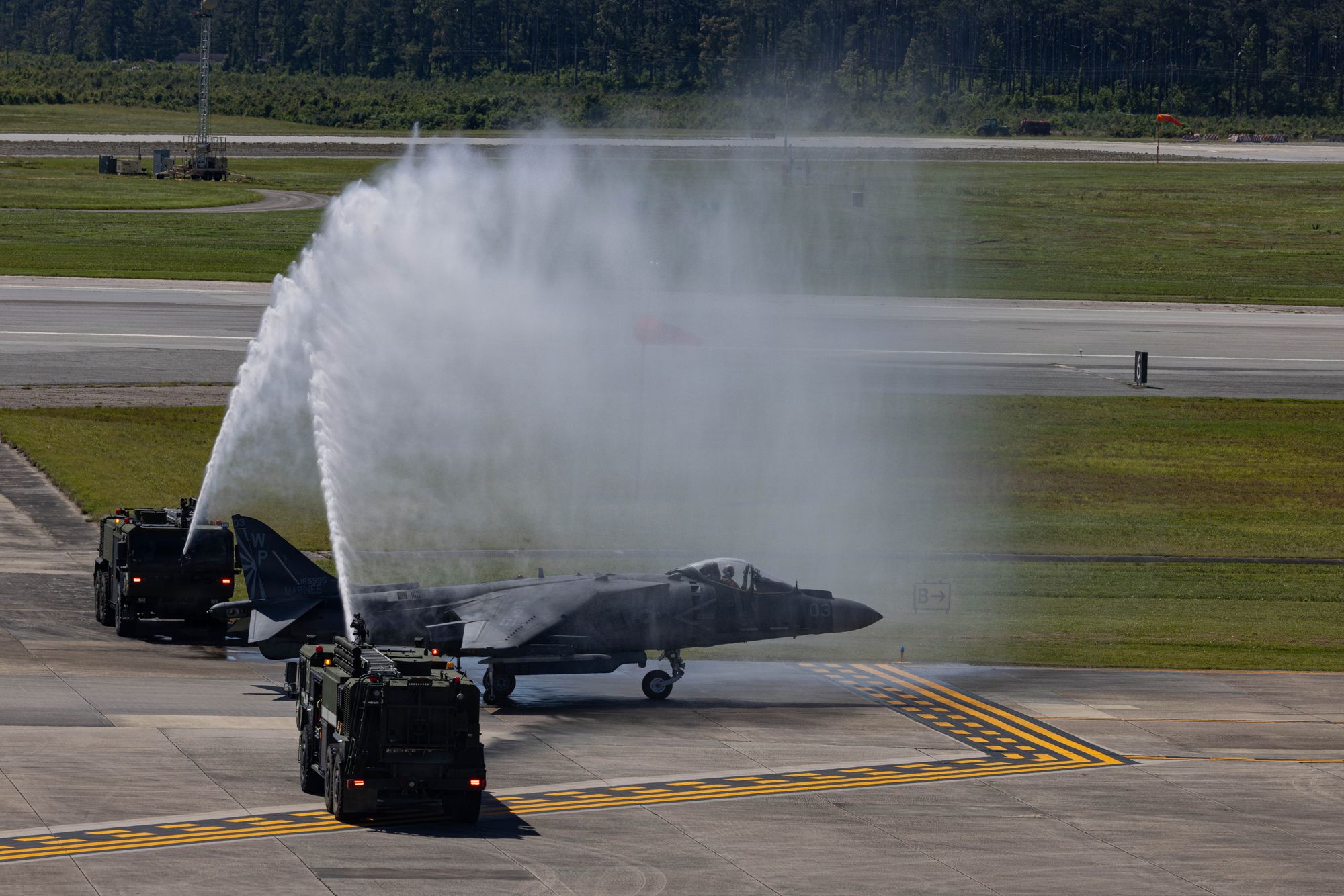 Et amerikansk AV-8B Harrier II-fly får en vannsalutt idet flyene blir tatt helt ut av tjeneste i U.S. Marine Corps.
