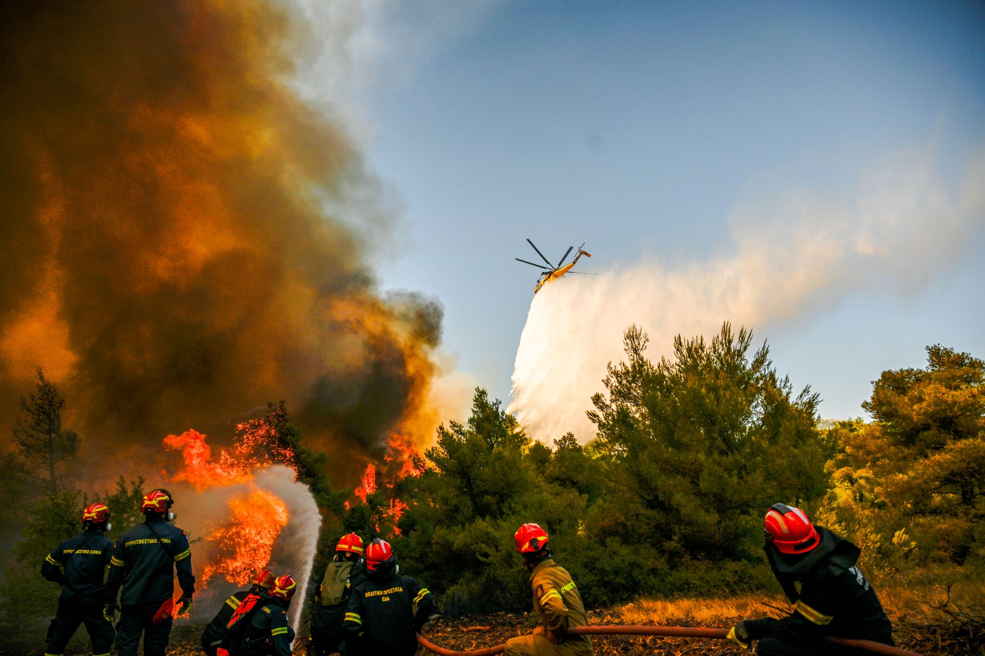Et brannhelikopter slipper ned vann på en røykfyllt skog under en skogbrann nær Porto Germeno, nordvest for Aten i Hellas søndag 2. august 2026.